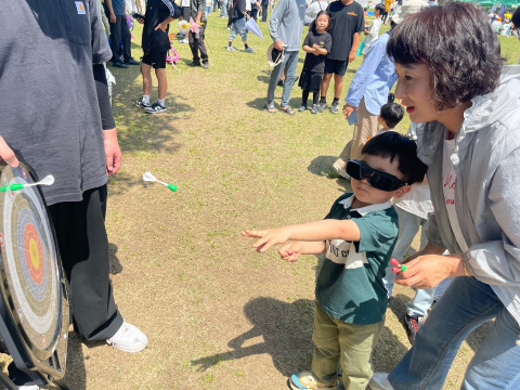 시각장애체험 안경 착용한 어린이들이 한궁을 체험하고 있다